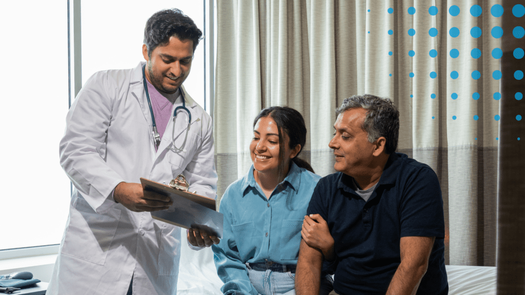 A doctor shows a clipboard to a patient and their advocate.