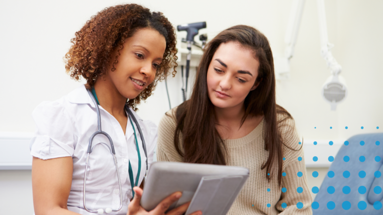 A doctor and patient both look over a tablet device together